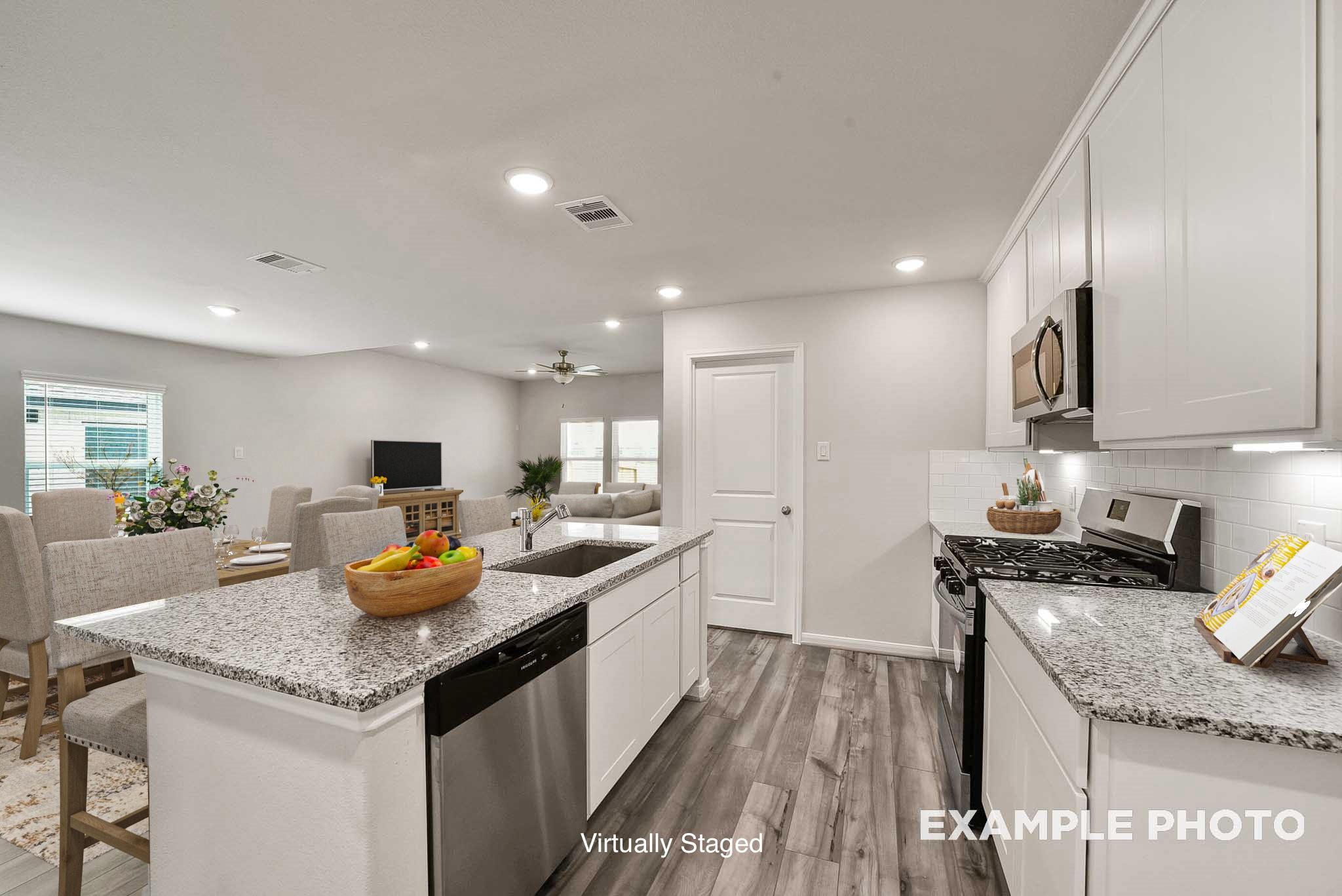 Open-concept kitchen and living area with white cabinets, granite counters, stainless appliances in Davidson Homes The Tierra B, Beasley, Texas