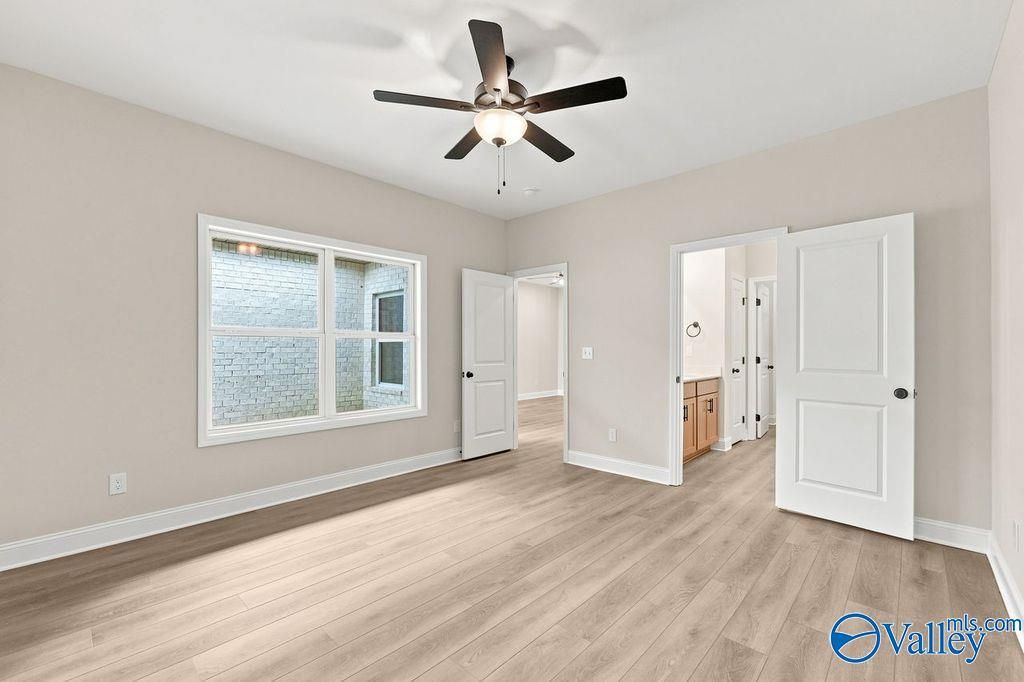 Bright, spacious bedroom with light wood flooring and ceiling fan in The Camilla C floor plan at The Retreat at Cain Park.