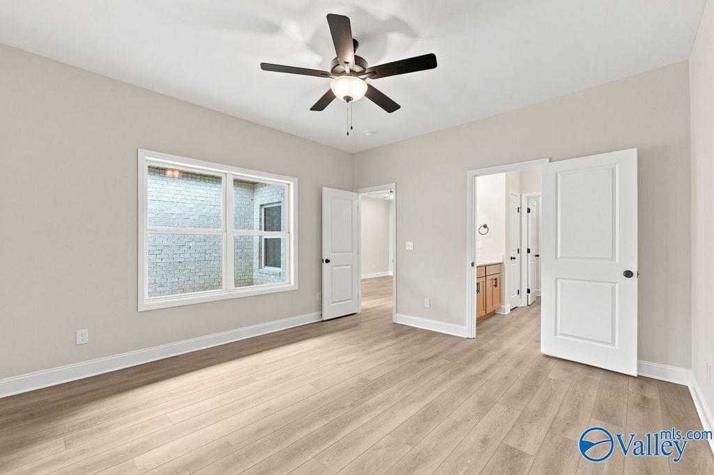 Bright, spacious bedroom with light wood flooring and ceiling fan in The Camilla C floor plan at The Retreat at Cain Park.