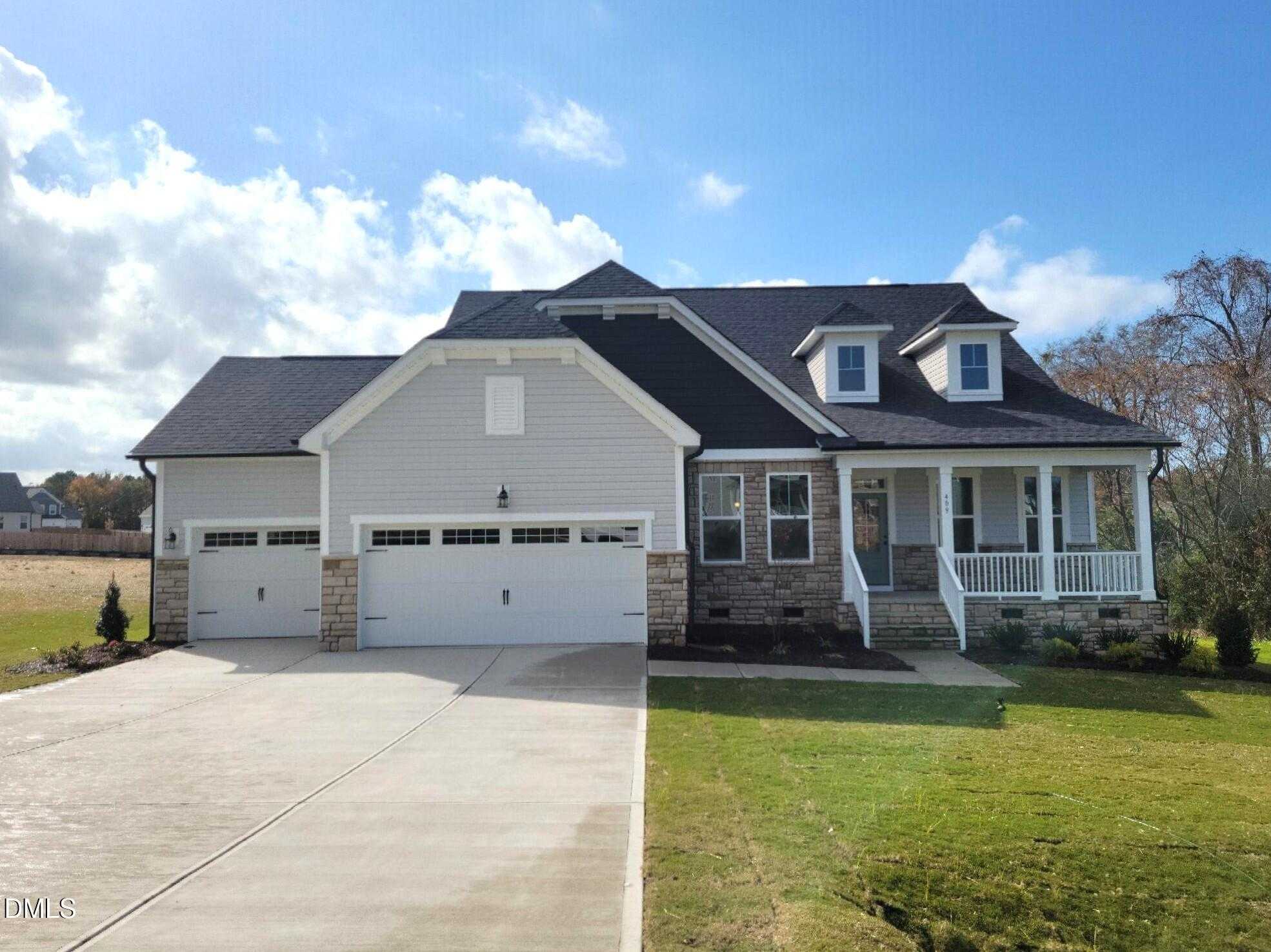 Davidson Homes Magnolia B exterior: 1.5-story gray home with black roof, dormers, 2-car garage, stone accents, front porch in Angier, NC