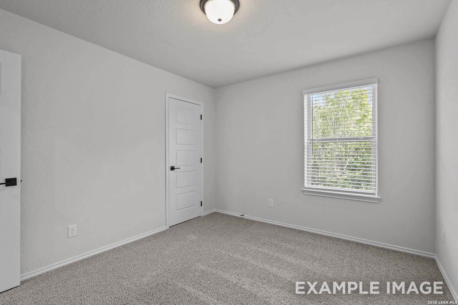 Bright secondary bedroom with neutral carpet and window in The Florence D floor plan by Davidson Homes, San Antonio, TX.