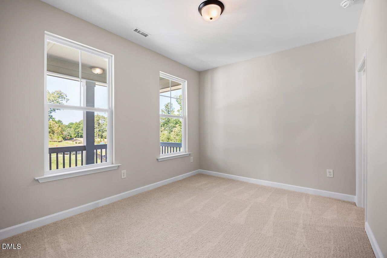 Bright, carpeted bedroom with large windows in The Chestnut floor plan by Davidson Homes in Montrose, Aberdeen, NC.