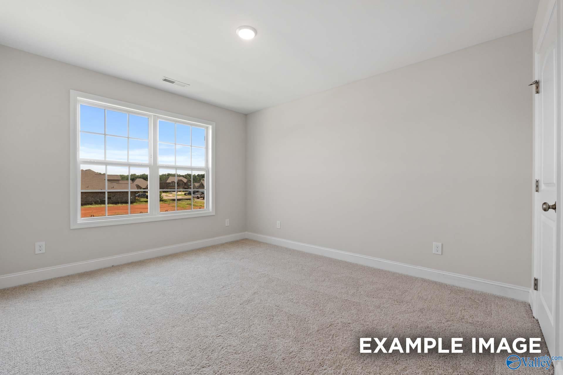 Bright secondary bedroom with large window view of neighborhood in Davidson Homes Madison A, Toney, Alabama