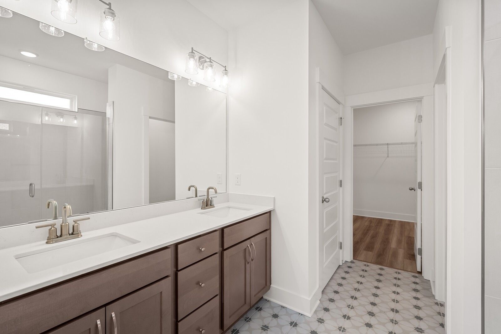Modern master bathroom featuring double vanity with quartz countertop, shaker cabinets, and frameless glass shower in Davidson Homes The Ash C, Mt. Juliet