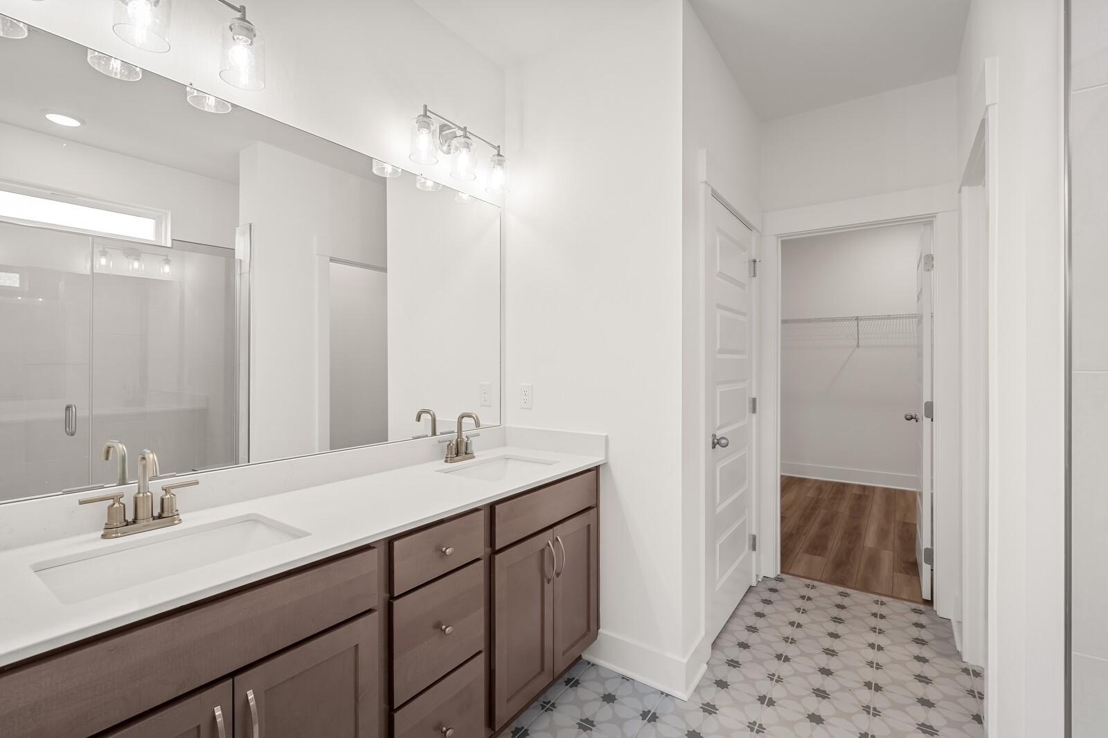 Modern master bathroom featuring double vanity with quartz countertop, shaker cabinets, and frameless glass shower in Davidson Homes The Ash C, Mt. Juliet