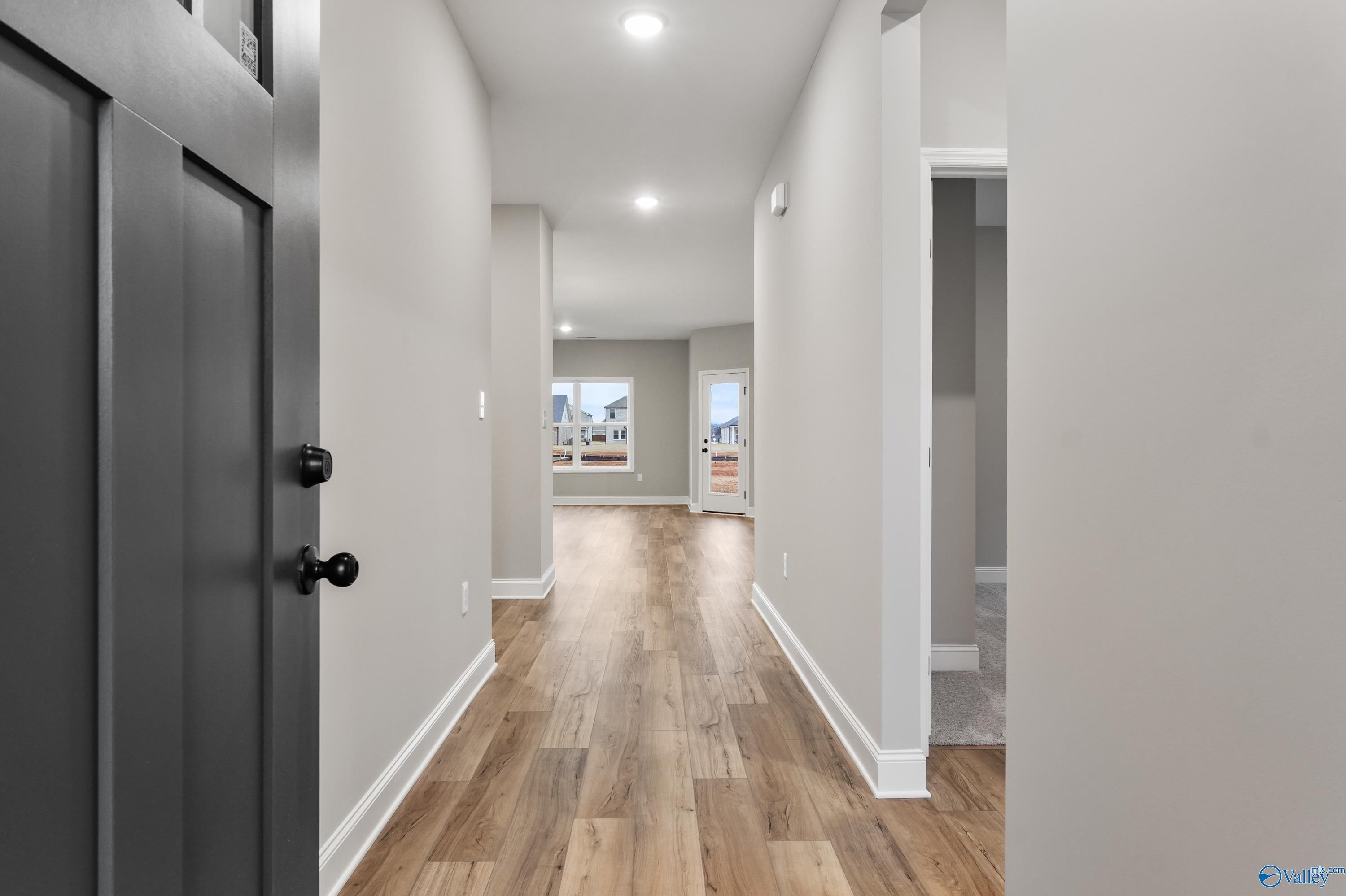 Modern hallway with hardwood floors, gray walls, and recessed lighting in Davidson Homes The Asheville C, Meridianville, AL