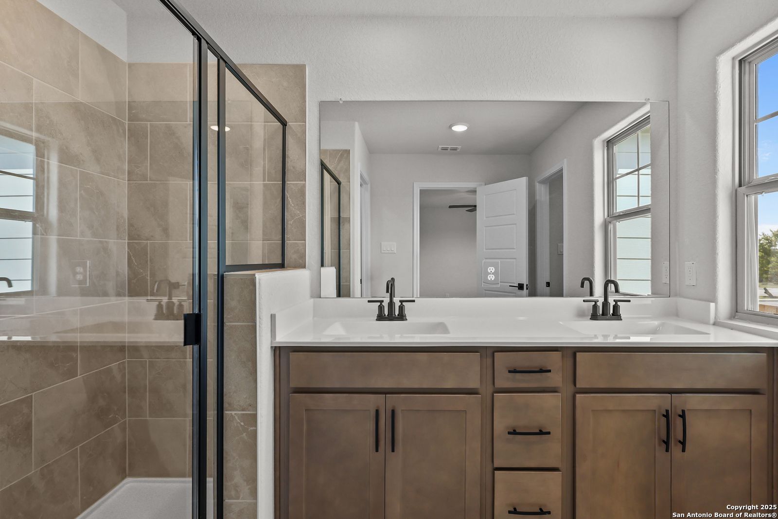 Modern master bathroom featuring frameless glass shower and double vanity in Davidson Homes The Florence C, San Antonio
