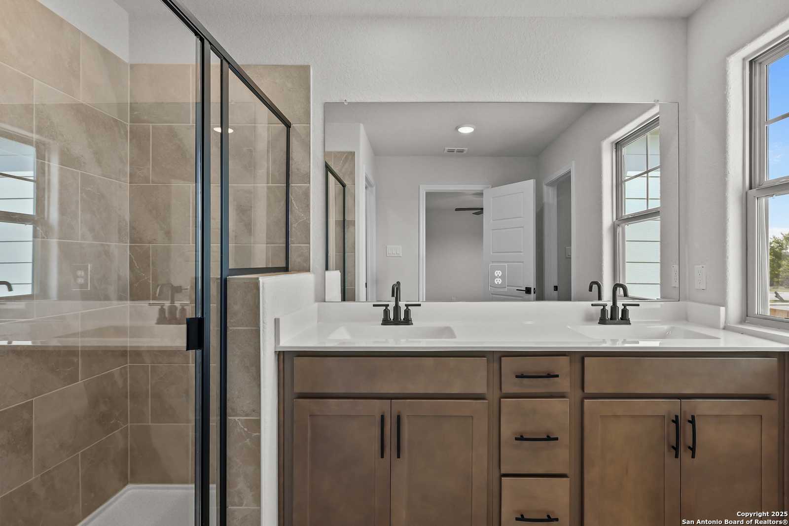 Modern master bathroom featuring frameless glass shower and double vanity in Davidson Homes The Florence C, San Antonio
