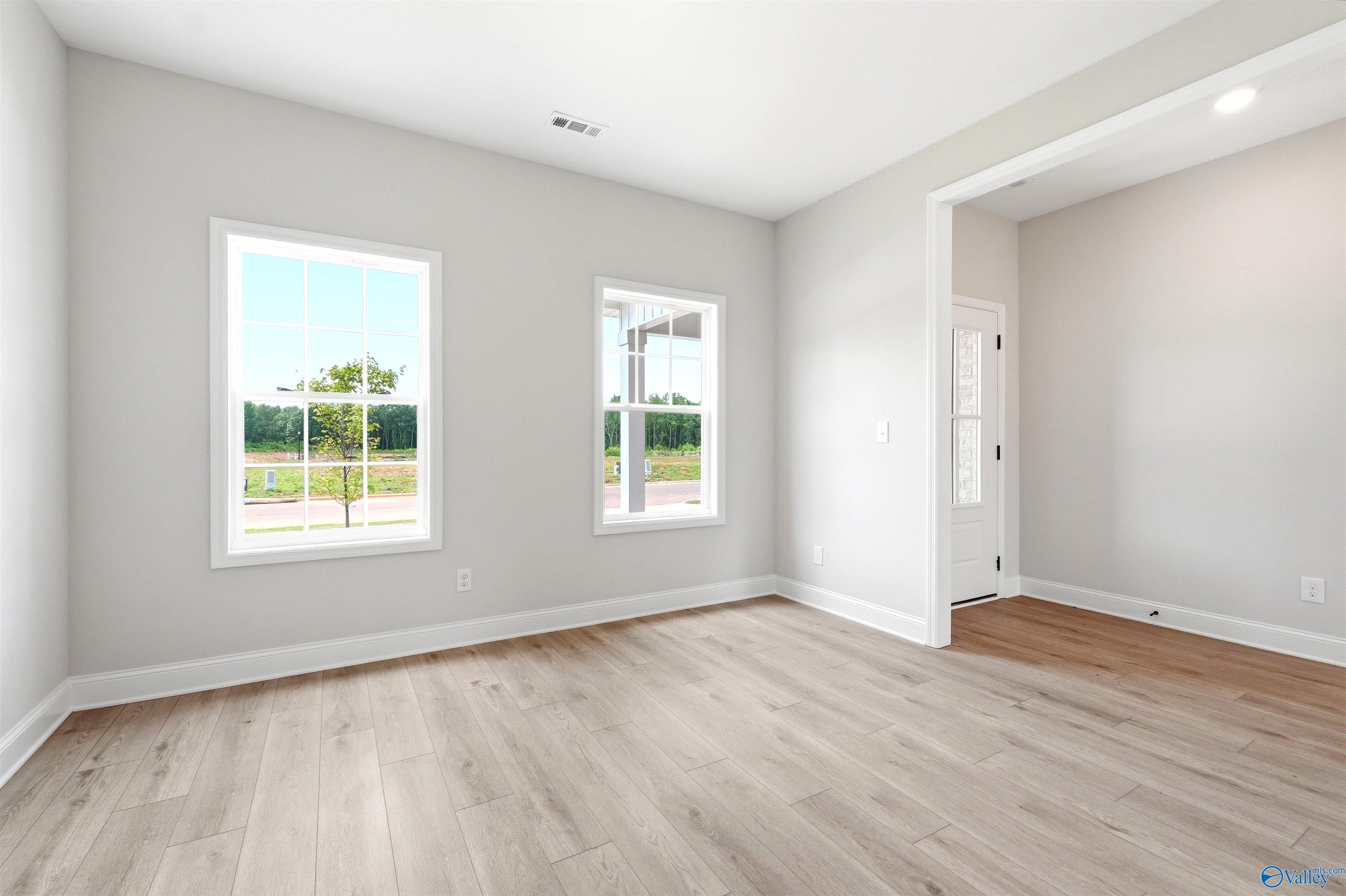Bright, spacious bedroom with light wood flooring and large windows in The Shelby A floor plan, Wood Trail, Toney, AL.