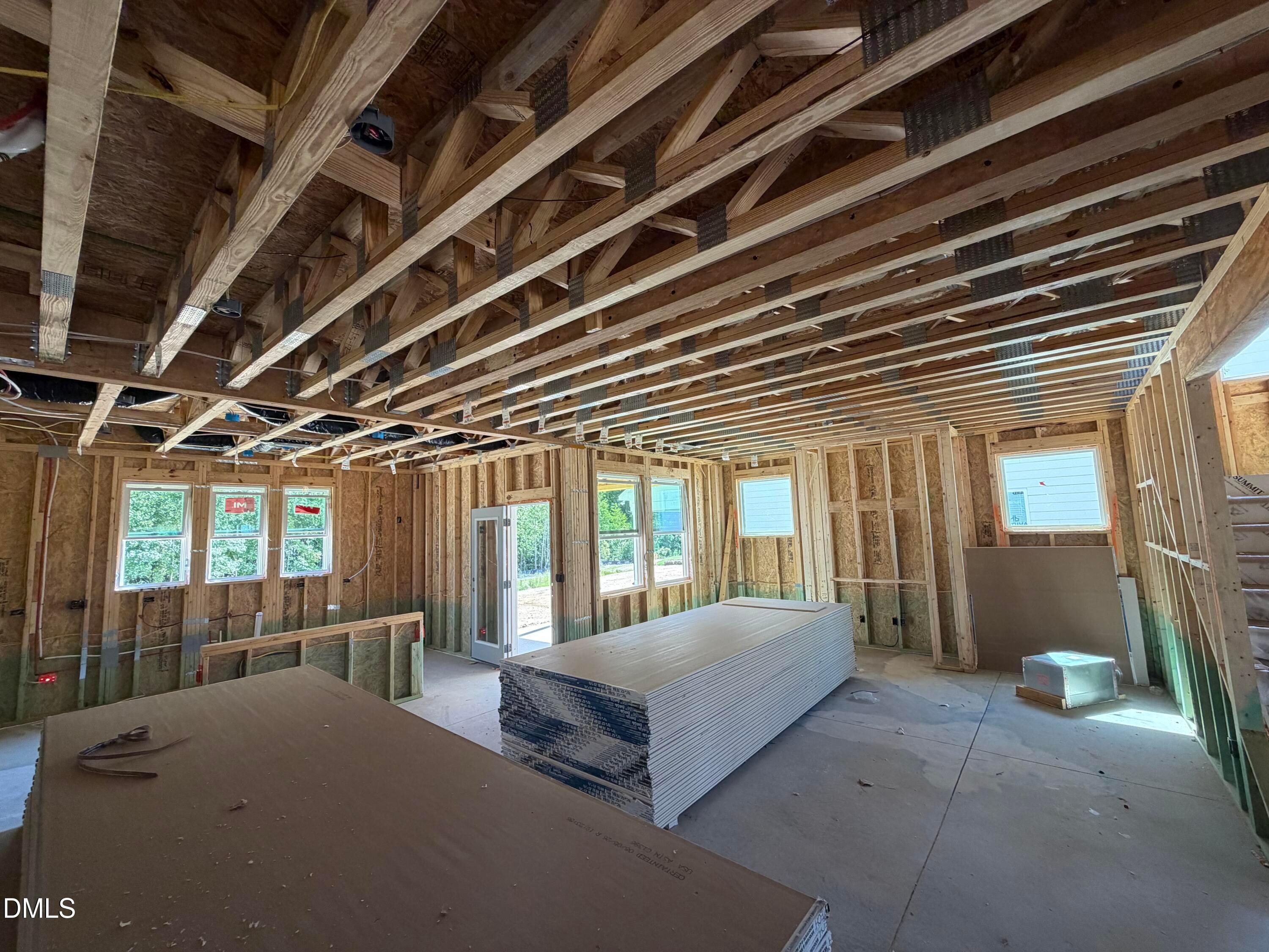 Framing and exposed ceiling trusses in unfinished great room of Davidson Homes The Aspen C new construction in Wendell Ridge, NC
