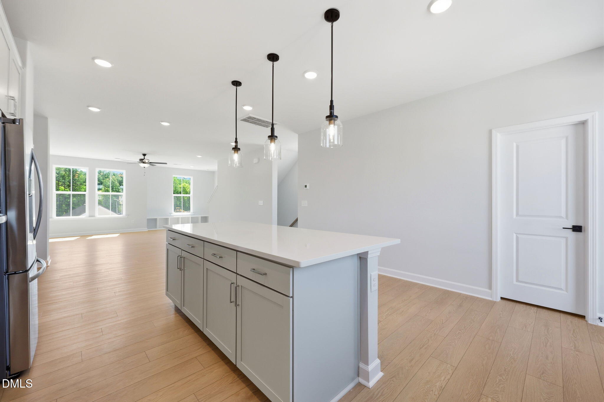 Modern kitchen island with quartz countertops and pendant lighting in The Avery floor plan, Forestville Yard Townhomes.