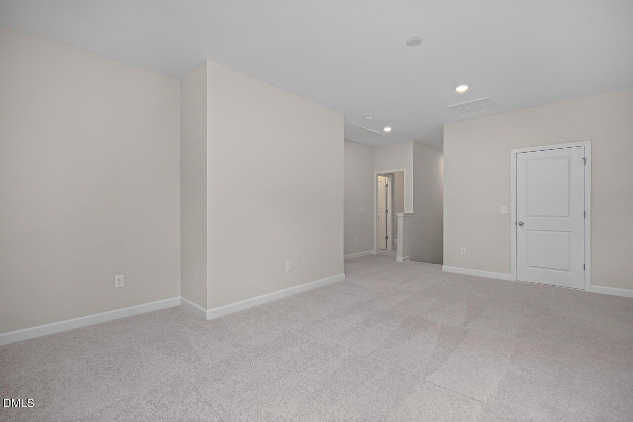 Spacious carpeted loft area in The Ashport G floor plan at Sage on North Main in Wake Forest, North Carolina.