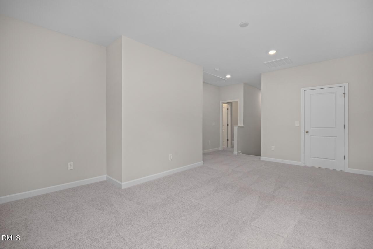 Spacious carpeted loft area in The Ashport G floor plan at Sage on North Main in Wake Forest, North Carolina.