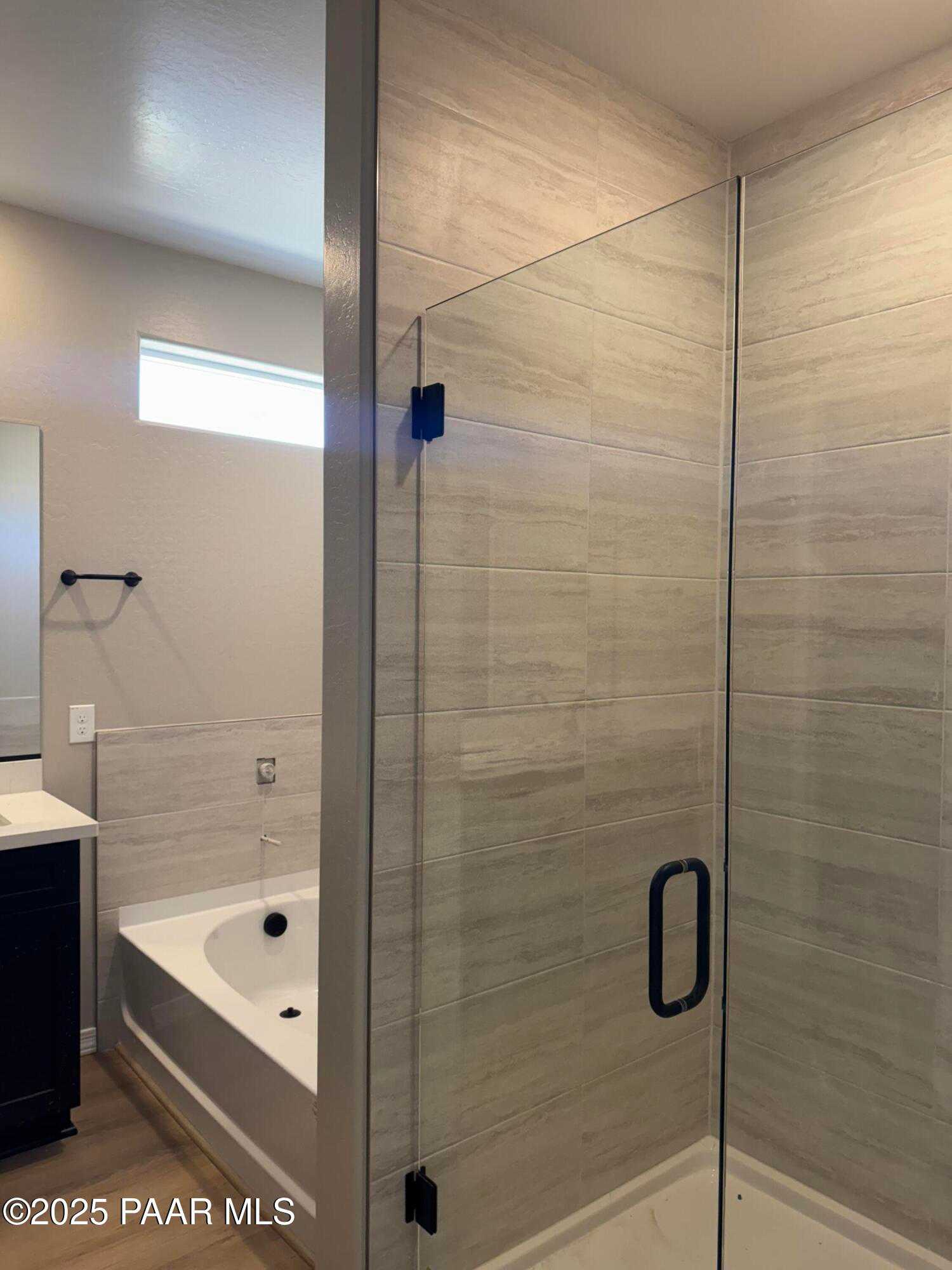 Modern master bathroom featuring frameless glass shower, soaking tub, and tiled vanity in Davidson Homes The Sheridan II B, Prescott, AZ