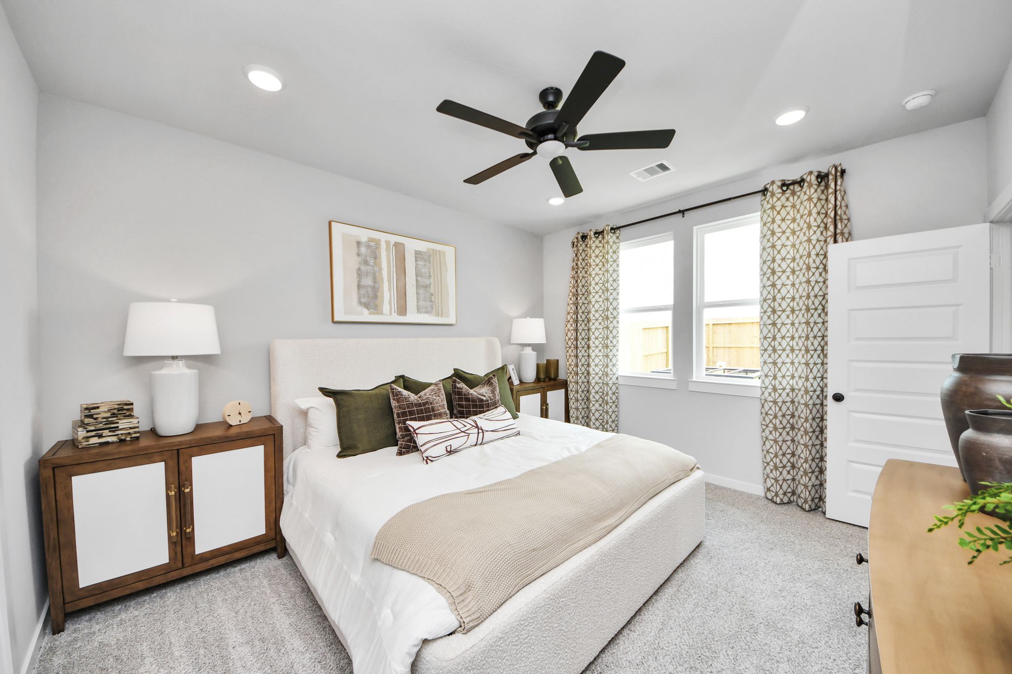 Cozy bedroom with plush bed, modern ceiling fan, and decor at Robins Landing in Houston, TX by Davidson Homes.