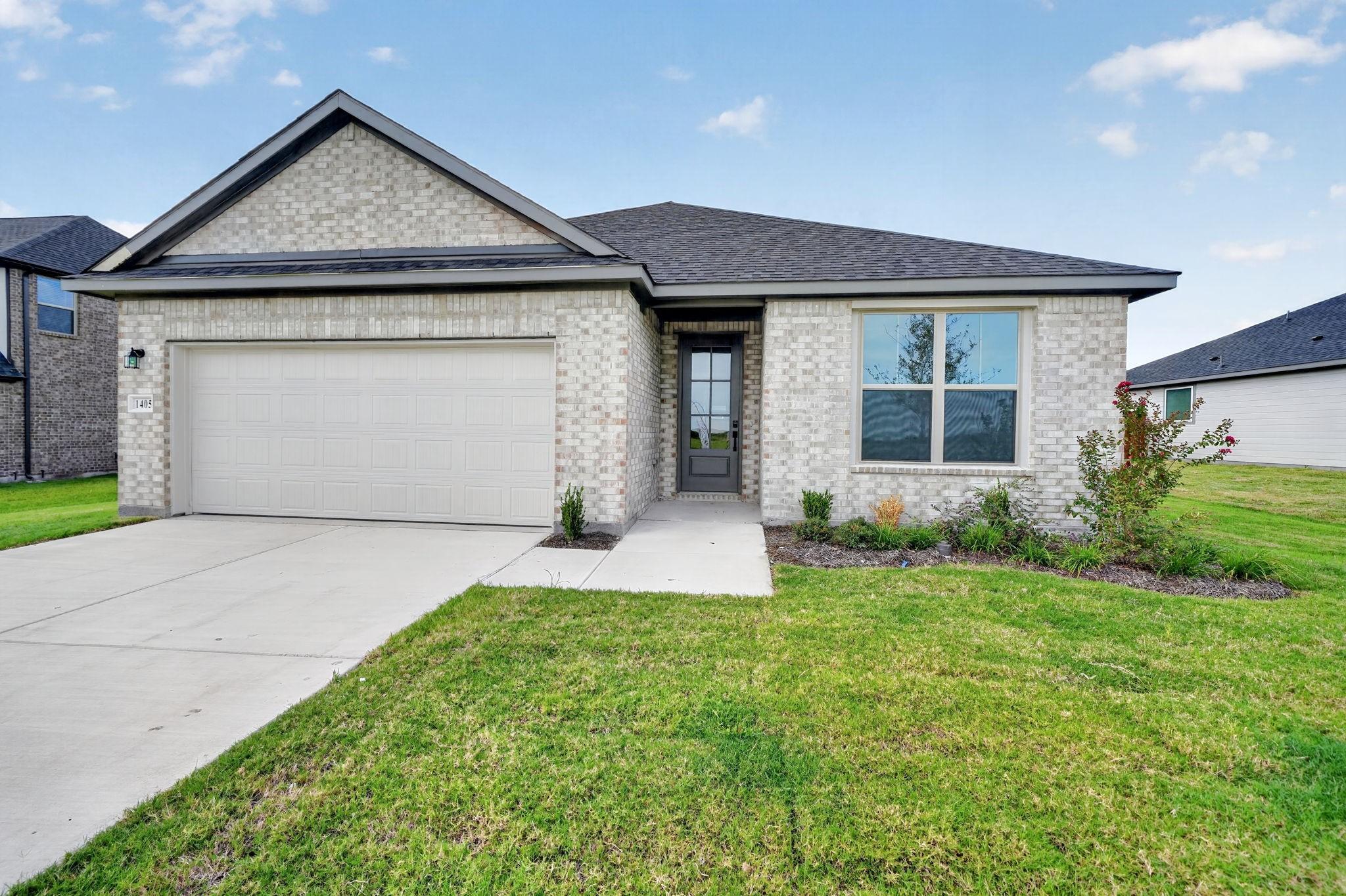 White brick exterior with 2-car garage and landscaped yard of Davidson Homes 4-bedroom The Holly F plan in Josephine, Texas