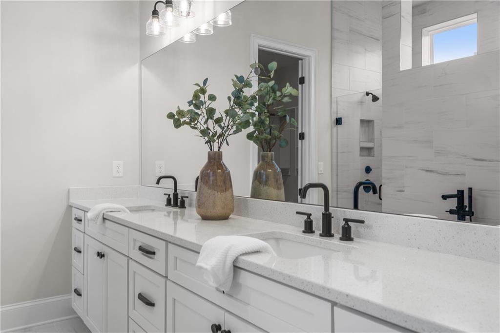 Elegant master bathroom double vanity with quartz counters, white shaker cabinets, black faucets in Davidson Homes Seaside B, Woodstock GA