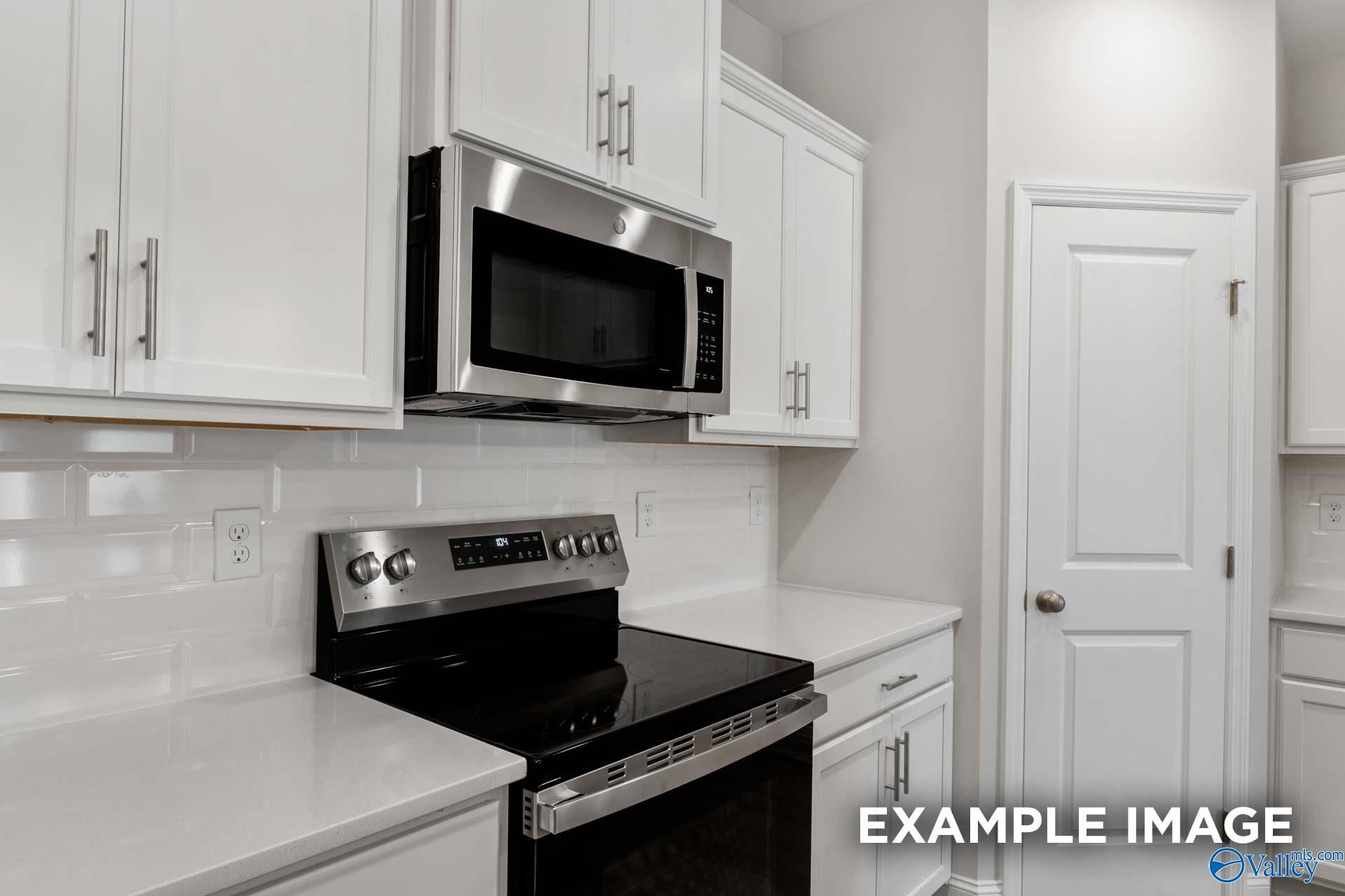 Modern kitchen featuring white shaker cabinets, stainless steel appliances, subway tile backsplash in Davidson Homes The Camilla B, Hartselle