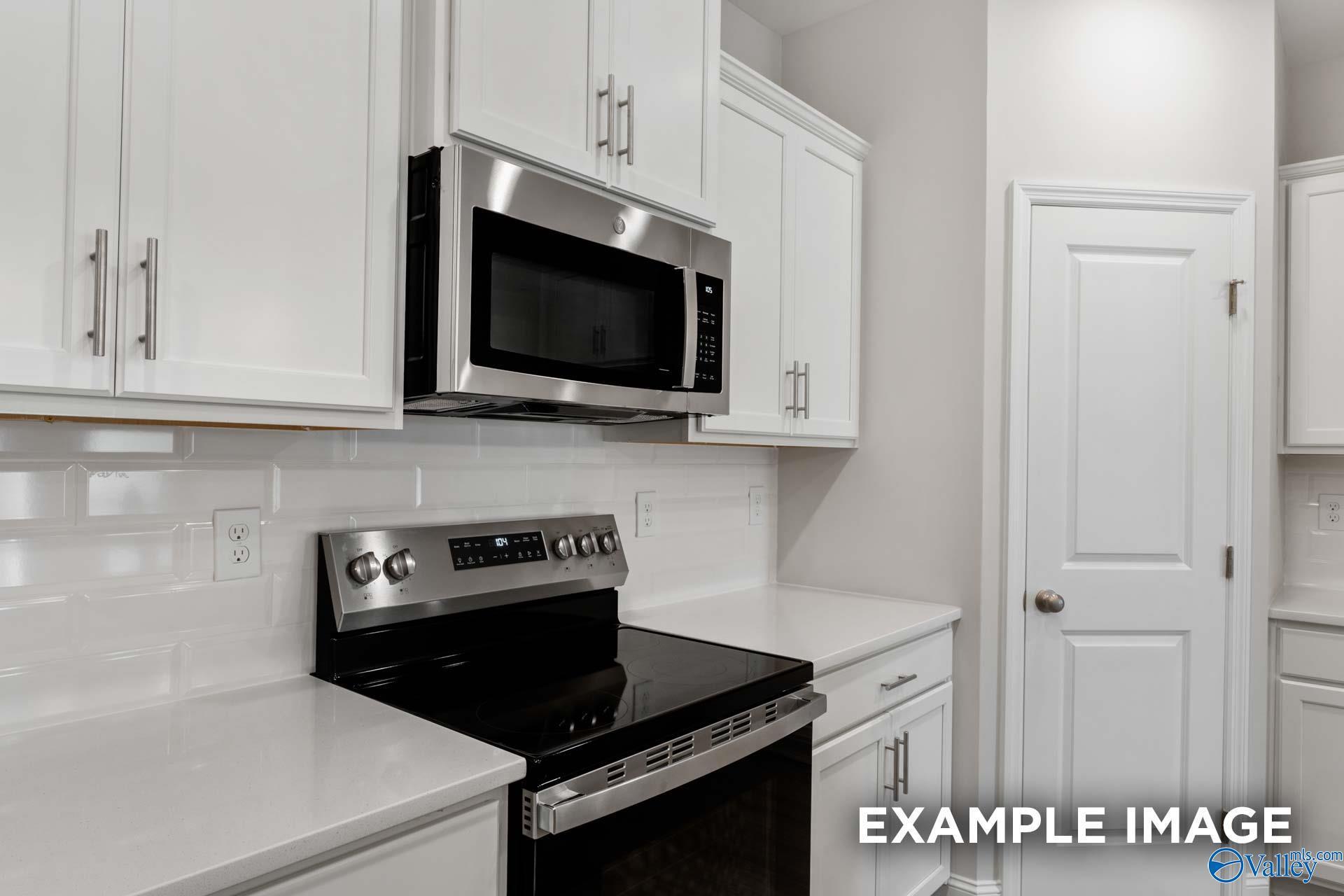 Modern kitchen featuring white shaker cabinets, stainless steel appliances, subway tile backsplash in Davidson Homes The Camilla B, Hartselle