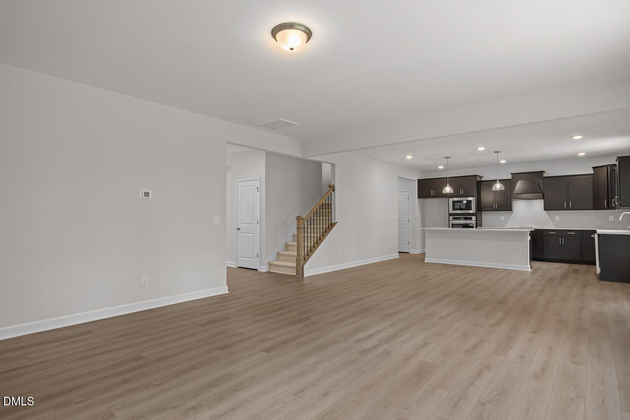 Open-concept living room and kitchen with dark cabinetry in The Hickory II B floor plan, Wellers Knoll, Lillington, NC.