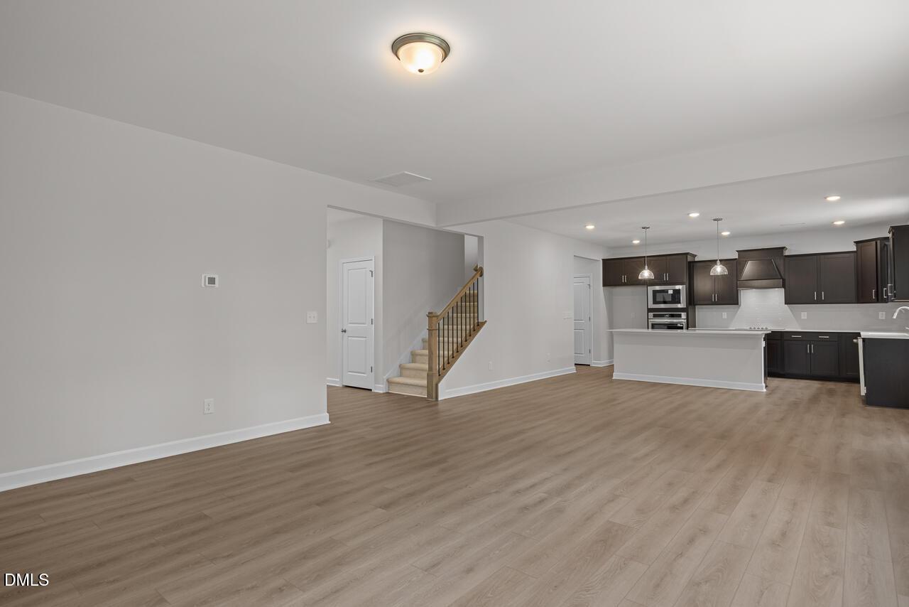 Open-concept living room and kitchen with dark cabinetry in The Hickory II B floor plan, Wellers Knoll, Lillington, NC.