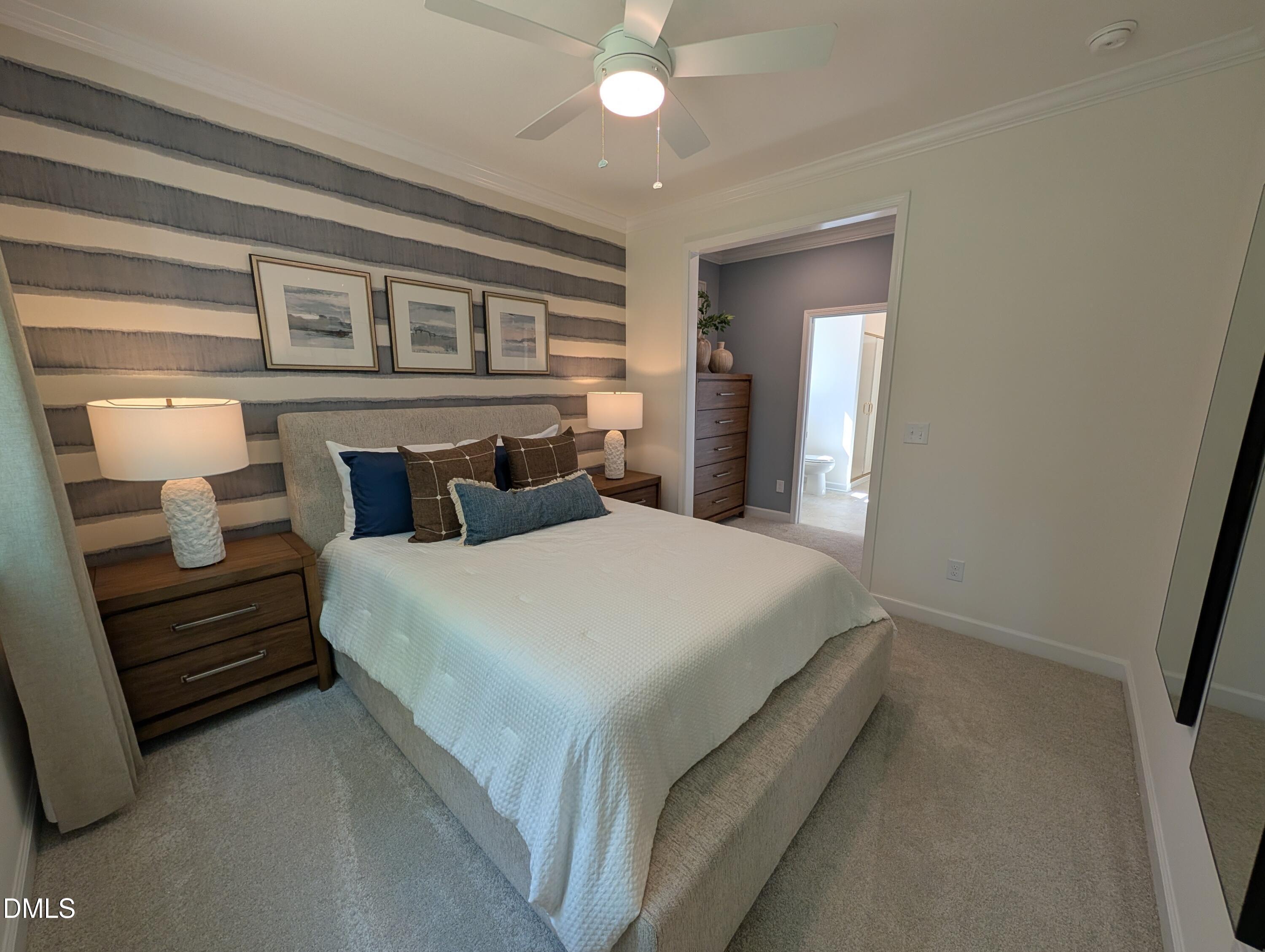 Cozy bedroom with striped accent wall in The Aspen B floor plan at Wendell Ridge, Wendell, North Carolina.