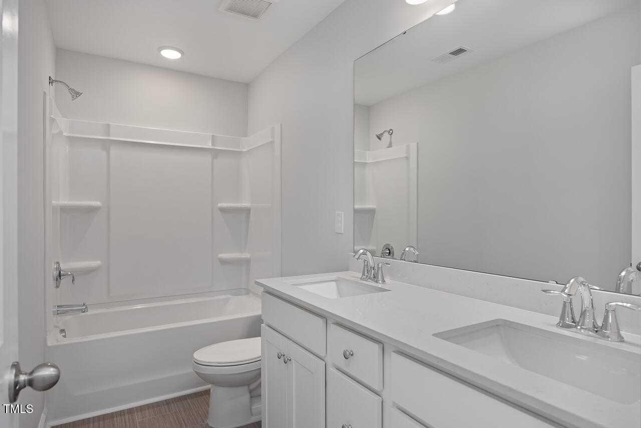 Modern master bathroom featuring double vanity, soaking tub, and walk-in shower in Davidson Homes The Graham, Fuquay-Varina, NC