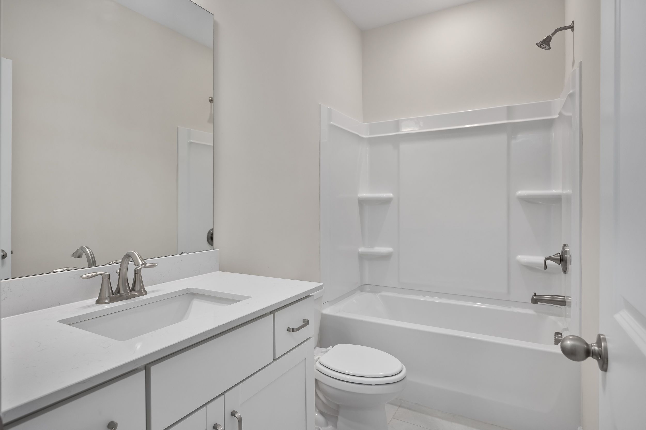Spacious bathroom in The Beech A by Davidson Homes featuring white vanity, single sink, large mirror, tub-shower combo, and toilet