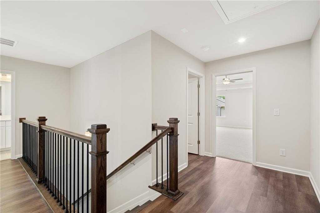 Elegant oak staircase with black metal balusters in upstairs hallway of Davidson Homes The Cary B, Kennesaw, Georgia