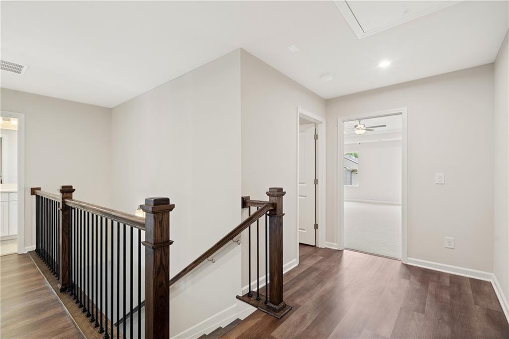Elegant wooden staircase with black metal balusters and hardwood floors in The Cary B 2-story home, Kennesaw, GA