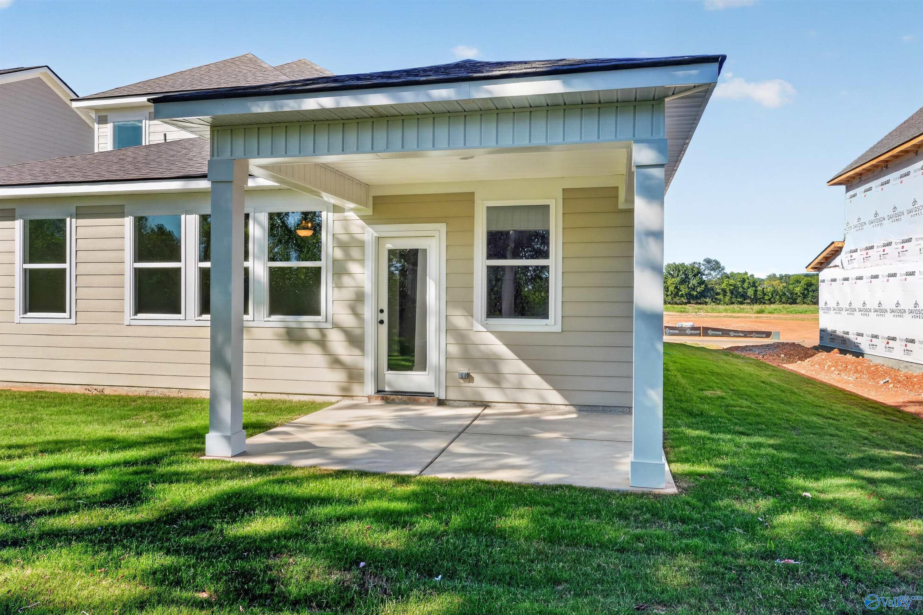 Covered back patio with concrete slab at Davidson Homes' The Ashport L in Berry Cove, New Market, Alabama