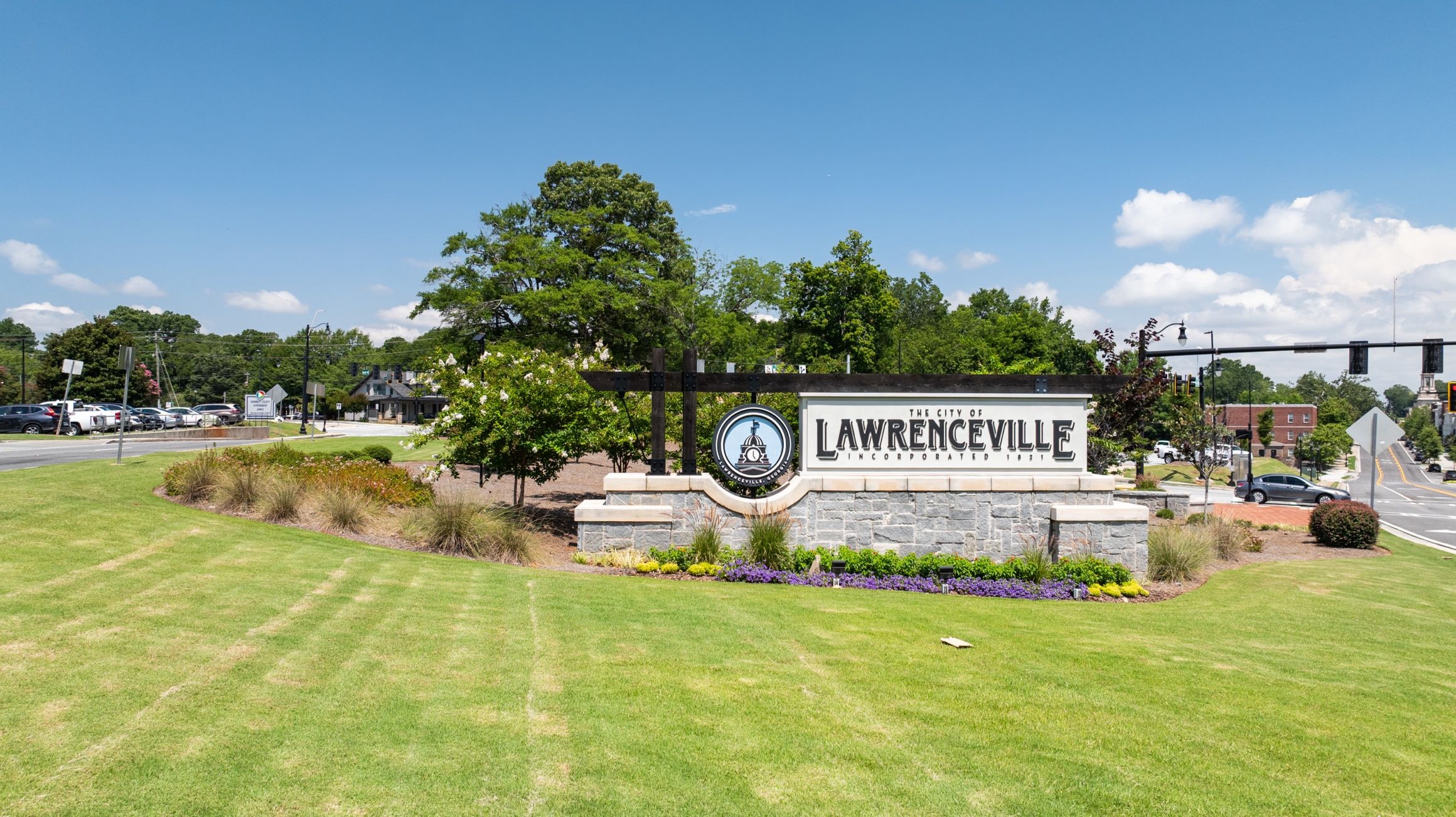 City of Lawrenceville welcome sign in Georgia with stone monument, landscaped flower beds, and green lawn near Alford at Bethesda