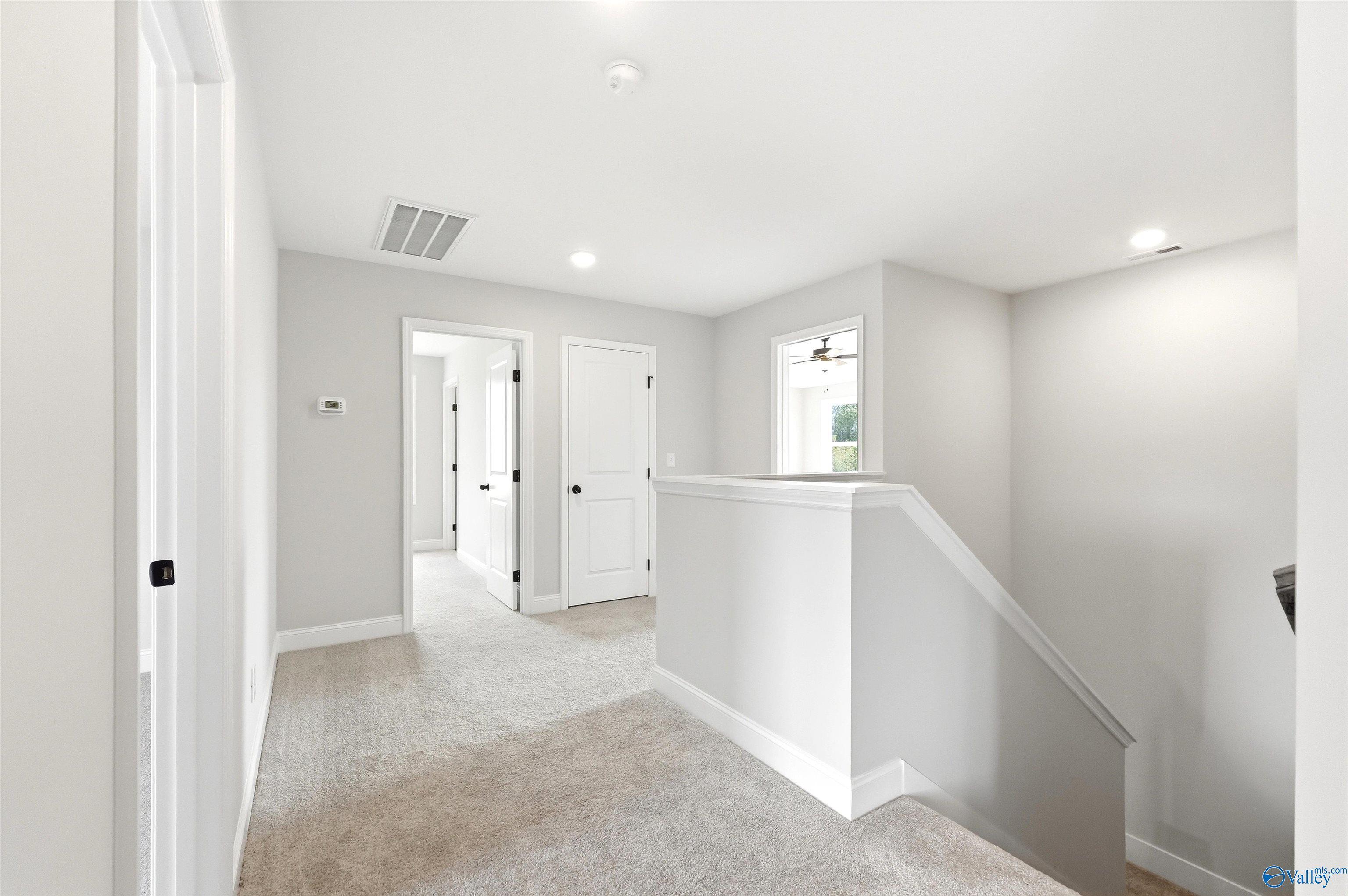 Bright, open carpeted upstairs landing in The Chelsea D floor plan by Davidson Homes in Berry Cove, New Market, Alabama.