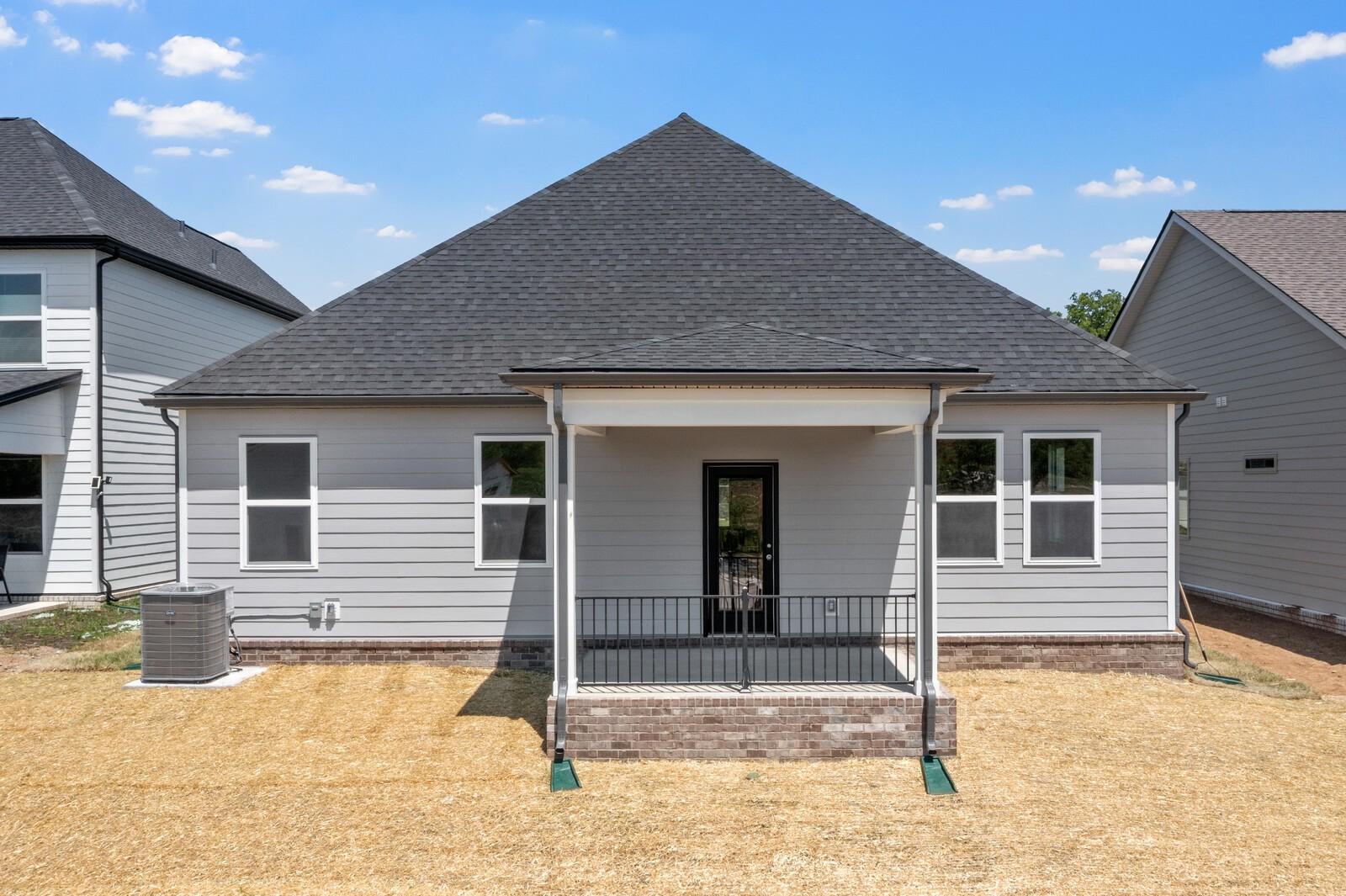 Back exterior of The Cottonwood E floor plan by Davidson Homes in Woods Crossing, Gallatin, featuring a covered patio.