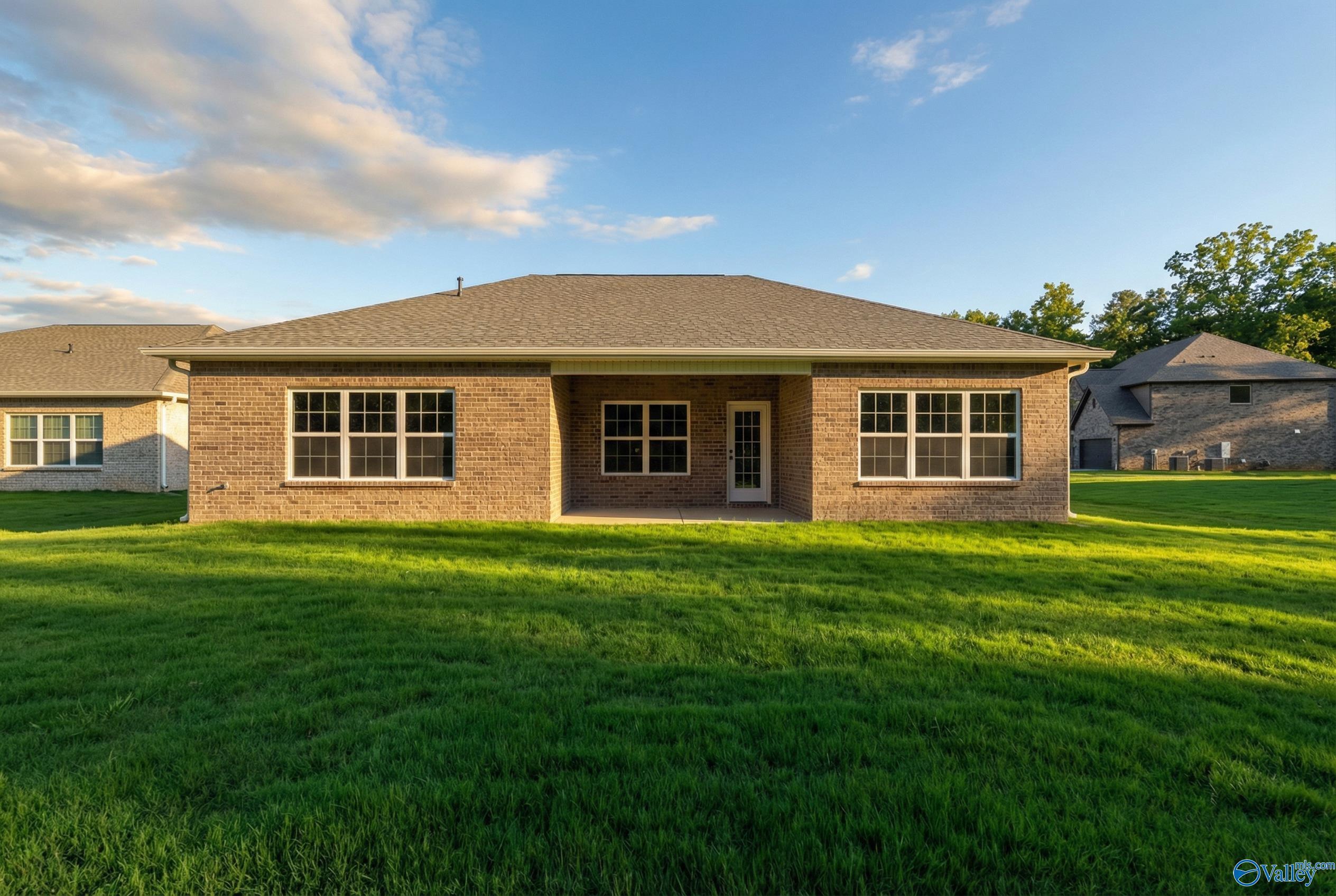 Charming one-story brick home with large windows, central entry, and lush green lawn in Cain Park, Hartselle, Alabama - The Montgomery B by Davidson Homes