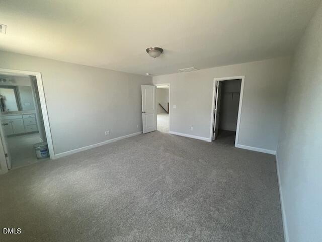 Spacious master bedroom with en-suite bath, walk-in closet, and gray carpet in Davidson Homes The Adalynn A, Lillington, NC