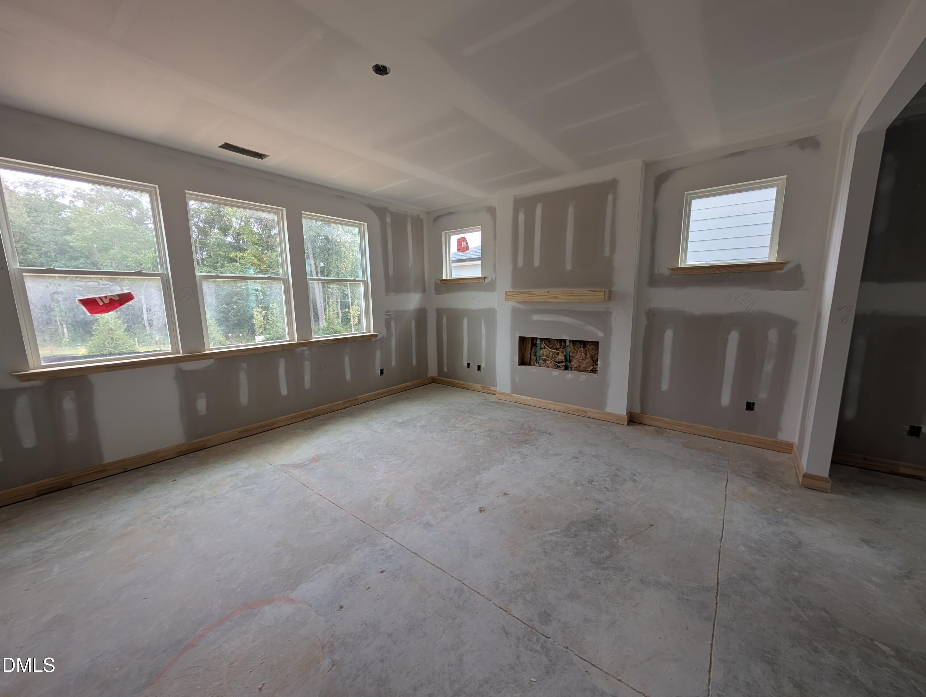 Spacious sunlit family room with fireplace and large windows under construction in Davidson Homes The Beech plan, Wendell Ridge, NC