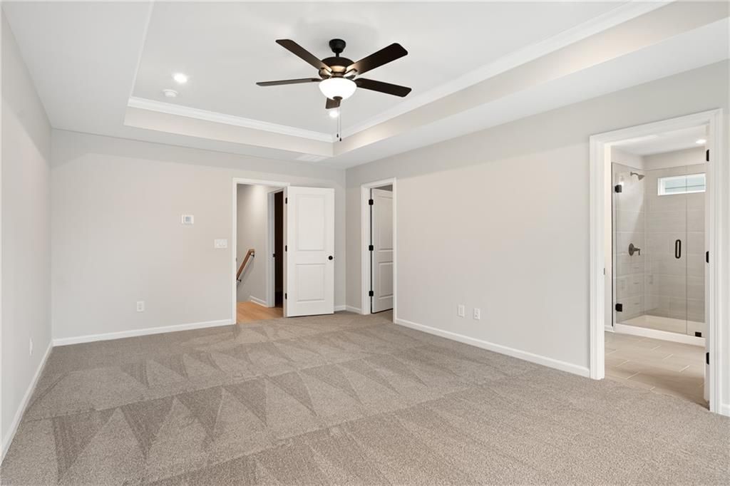 Modern upstairs hallway with ceiling fan, light gray walls, carpeted floors, and glass shower bathroom access in The Marion A floor plan, Kennesaw, GA