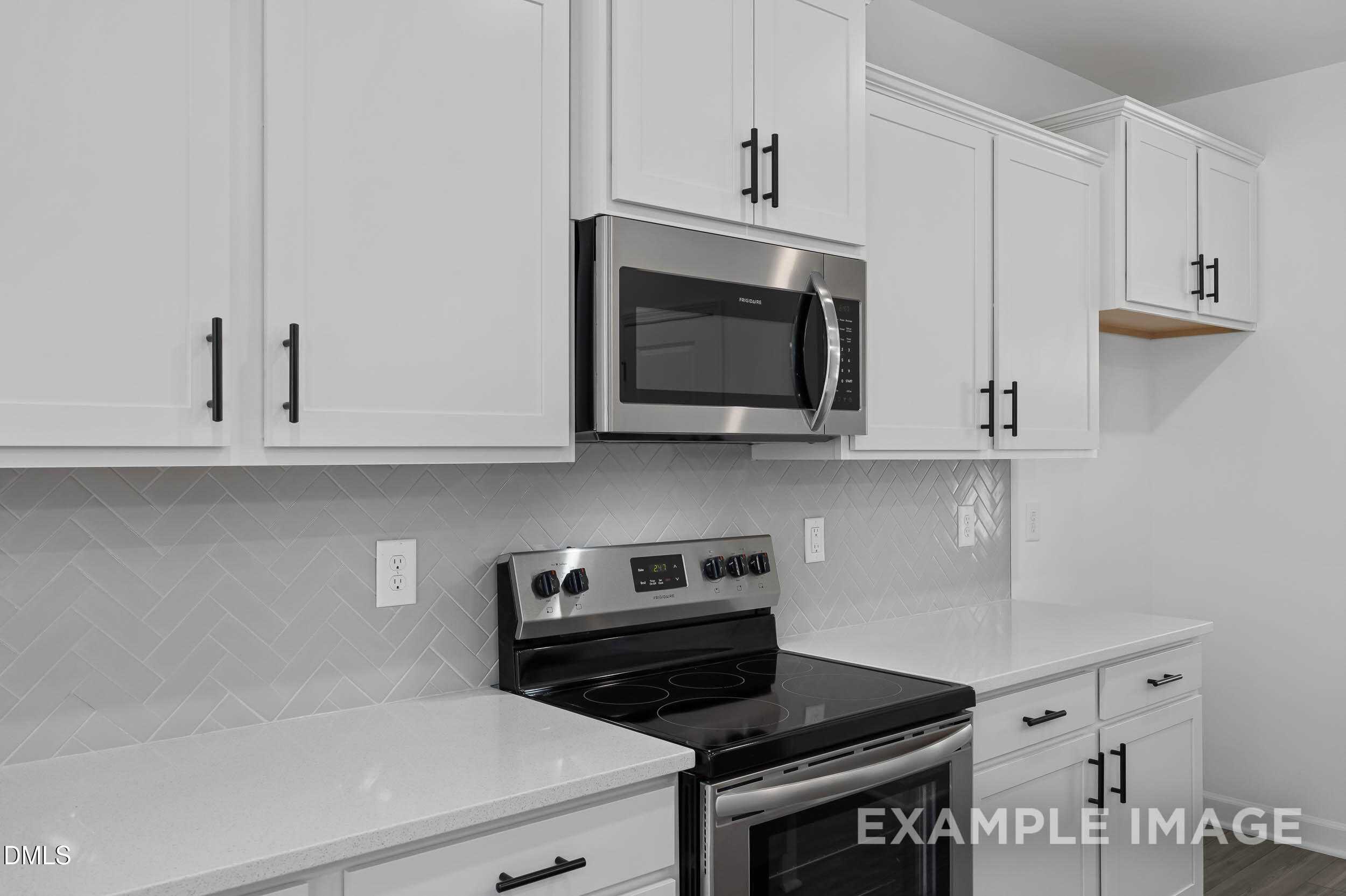 Modern white shaker kitchen with stainless steel appliances and subway tile backsplash in Davidson Homes The Willow D, Zebulon, NC