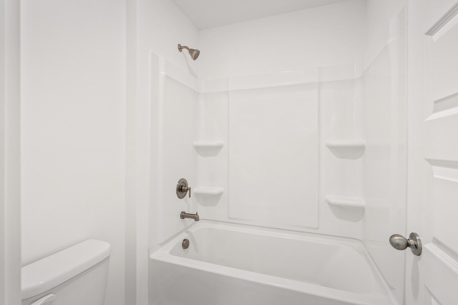 Bright white secondary bathroom with tub, tiled shower, and bronze fixtures in Davidson Homes The Ash C, Mt. Juliet, TN
