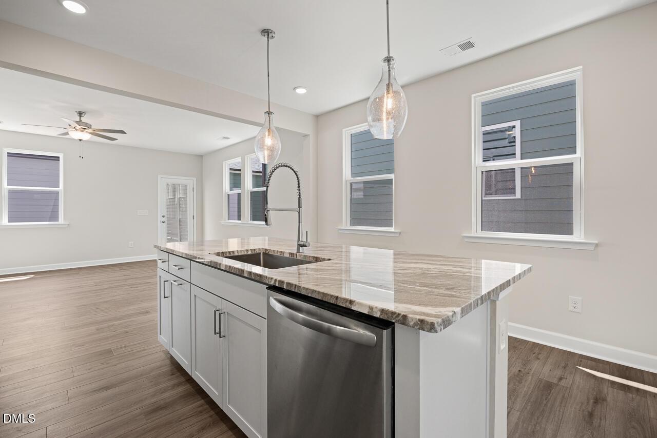 Modern kitchen island with granite countertops and stainless appliances in The Alexander C plan at Forestville Yard.