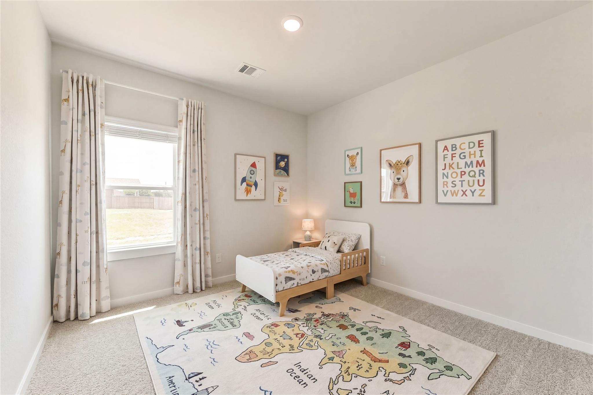 Cozy child's bedroom with world map rug, twin bed, and educational art in The Frio G by Davidson Homes, Magnolia, Texas