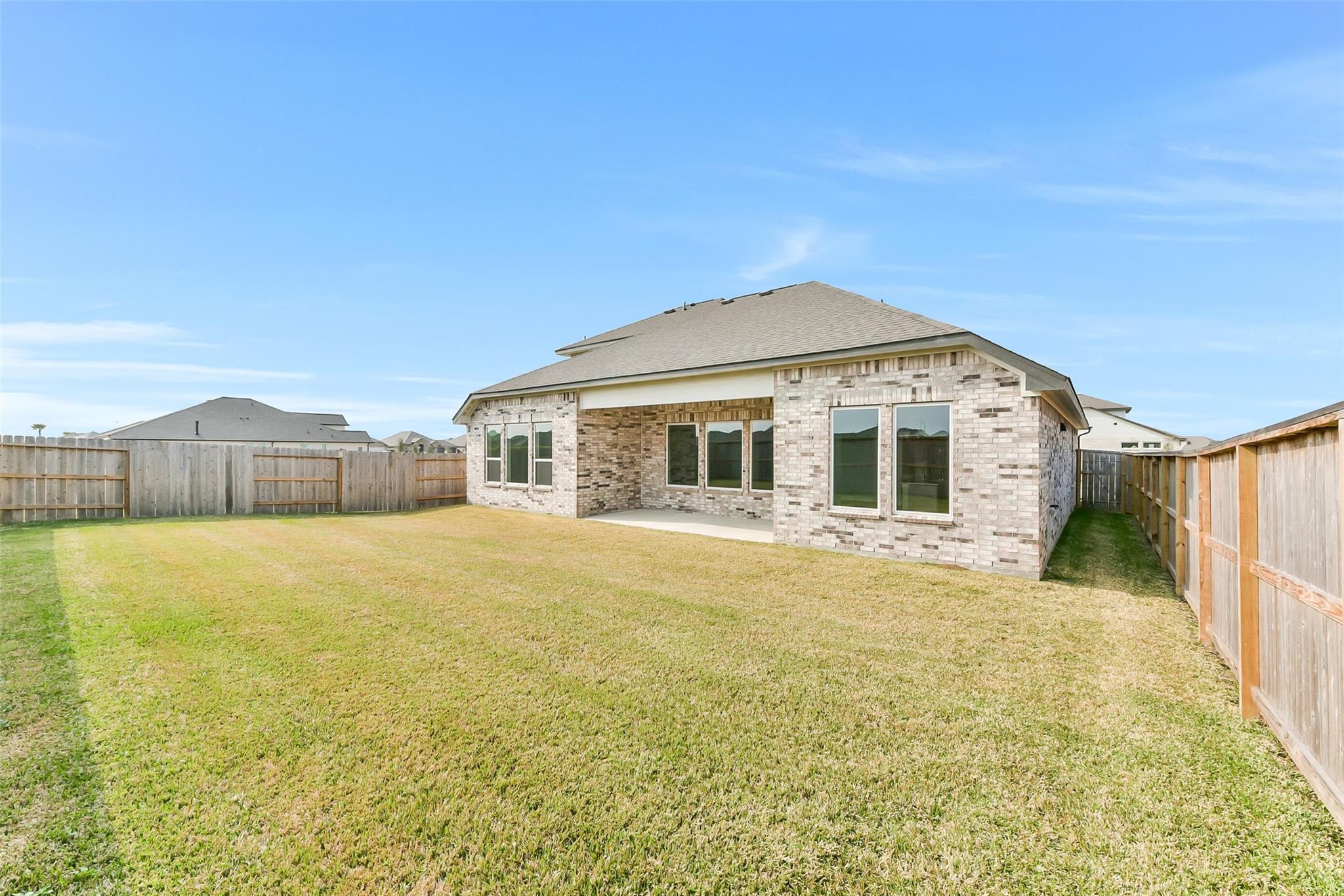 Spacious fenced backyard with covered patio on brick 1-story home, The Edward A by Davidson Homes in Lago Mar, Texas City