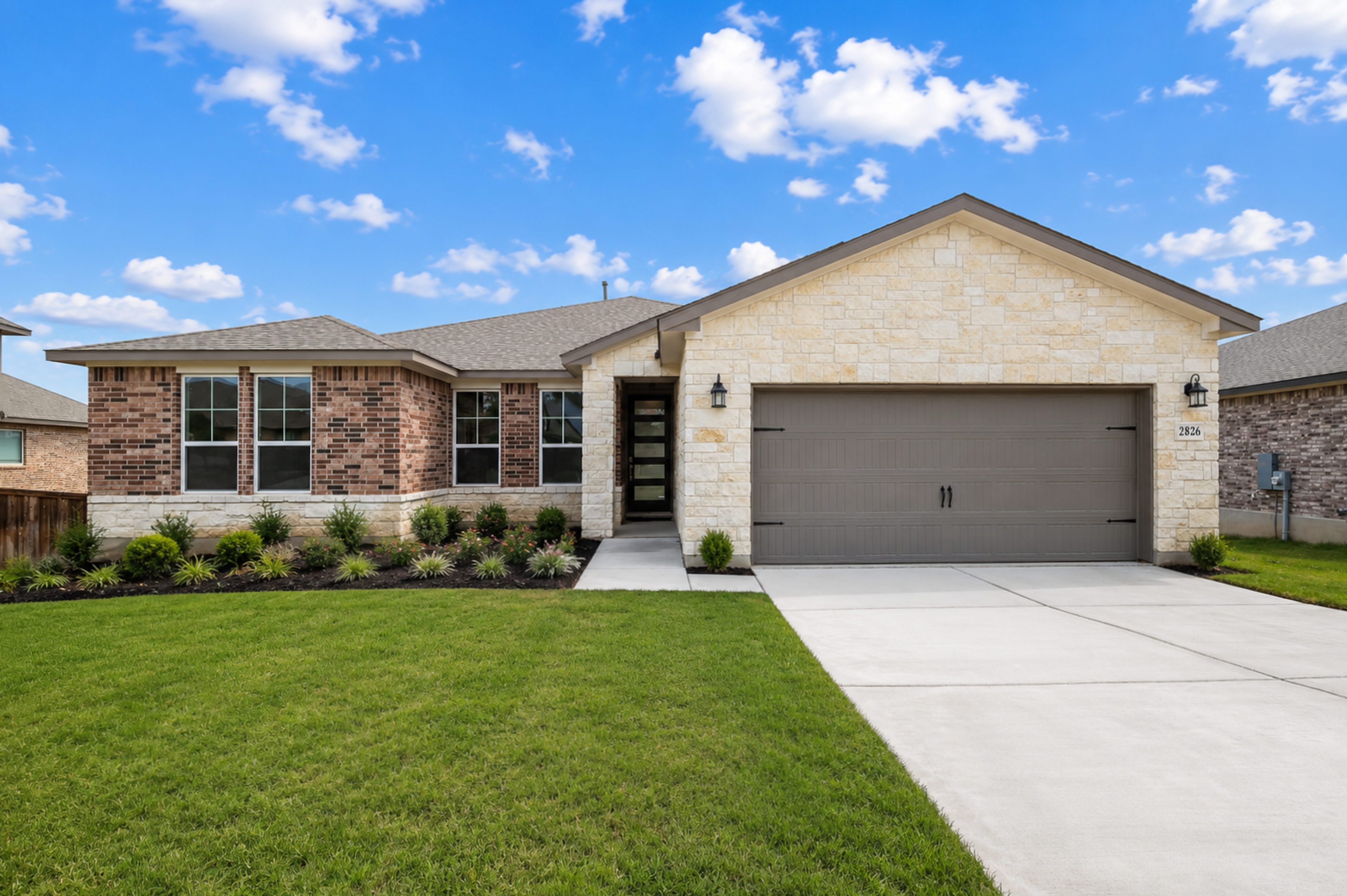 Cozy open-concept living room in Ladera San Antonio TX home with stone fireplace, exposed wood beams, ceiling fan, plush beige sofa and neutral decor