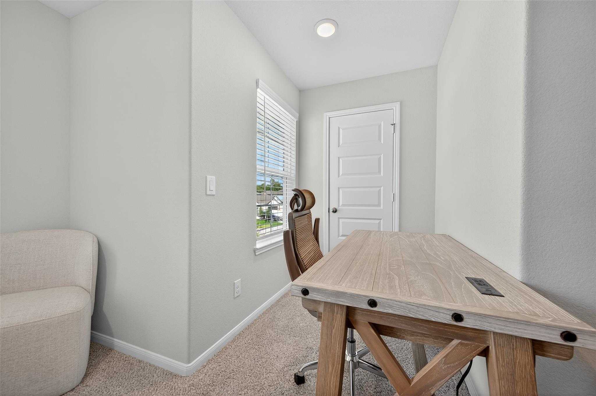 Cozy home office with wooden desk, ergonomic chair, and window blinds in 5-bedroom Davidson Homes The Brazos E, Magnolia, Texas