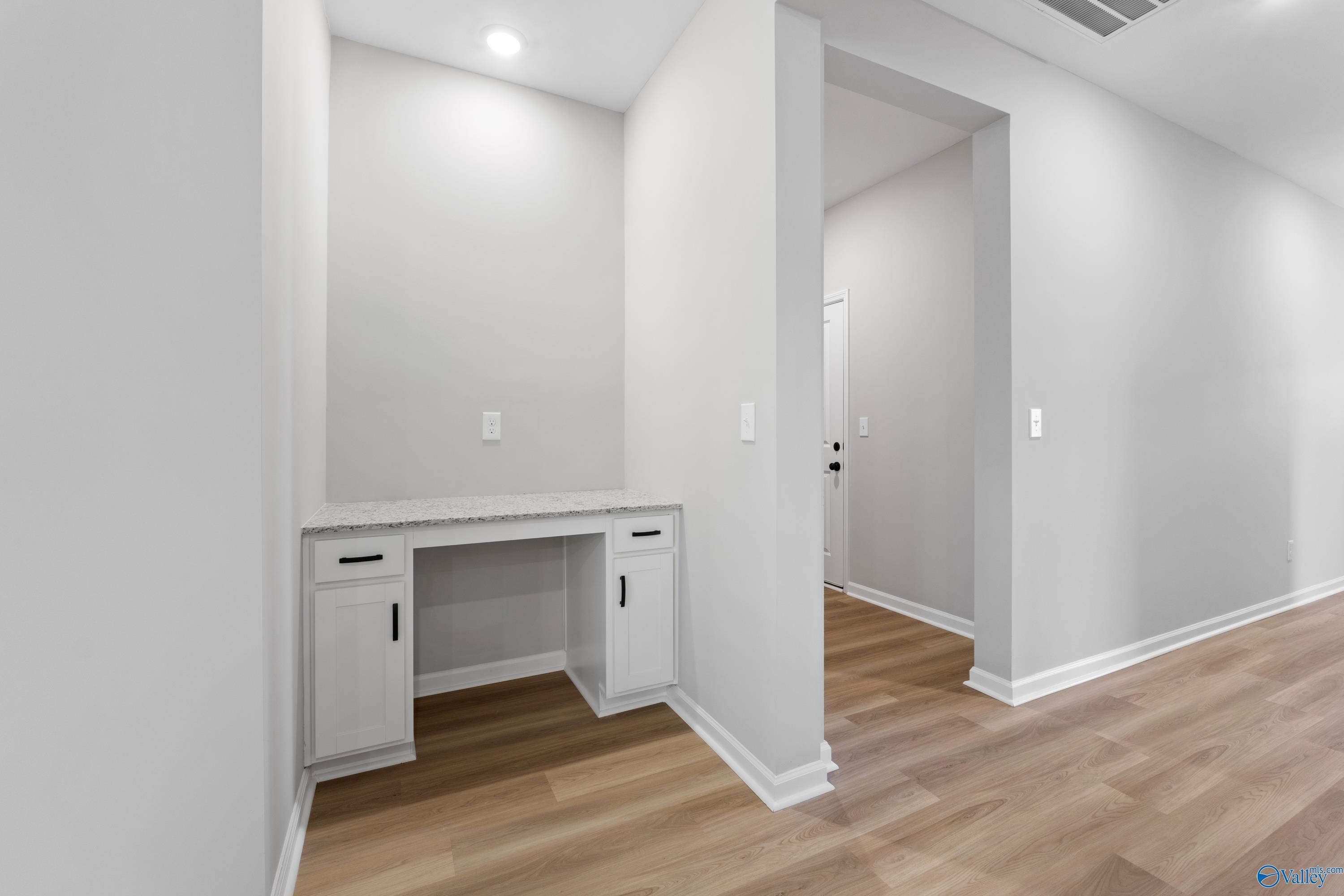 Modern built-in white desk with drawers in gray-walled study nook, hardwood floors, Davidson Homes The Phoenix floor plan, Hazel Green AL