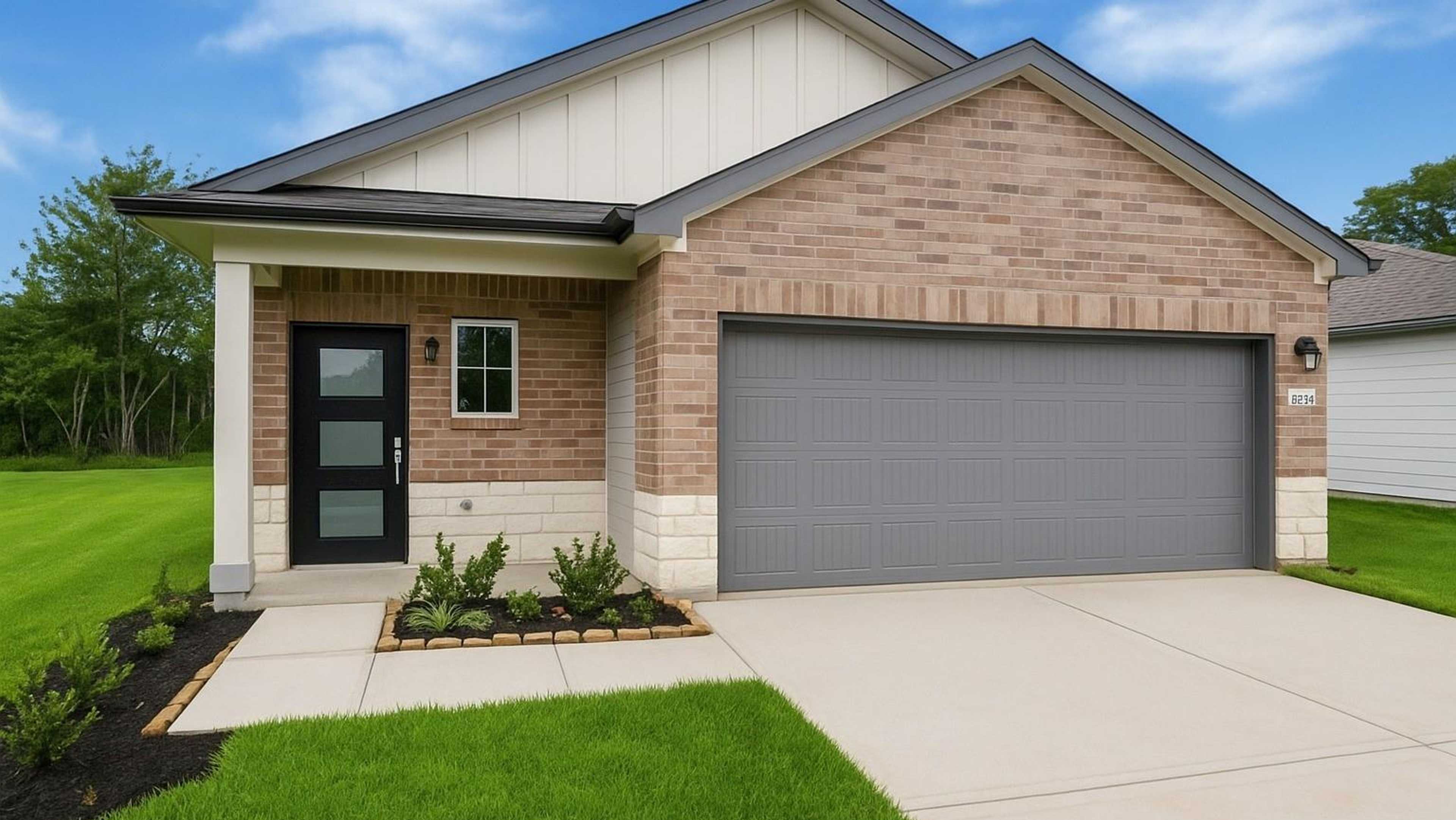 Modern brick Davidson Homes model at 2033 Caney Creek Court open house, gabled roof, garage, porch, lush lawn, blue sky