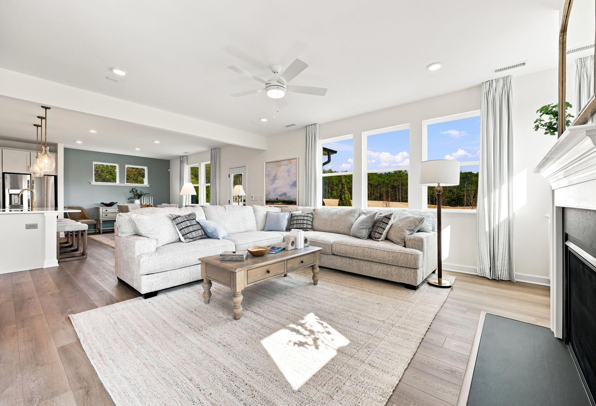 Open-concept living room in The Beech with sectional sofa, fireplace, and natural light in Holly Springs, North Carolina.