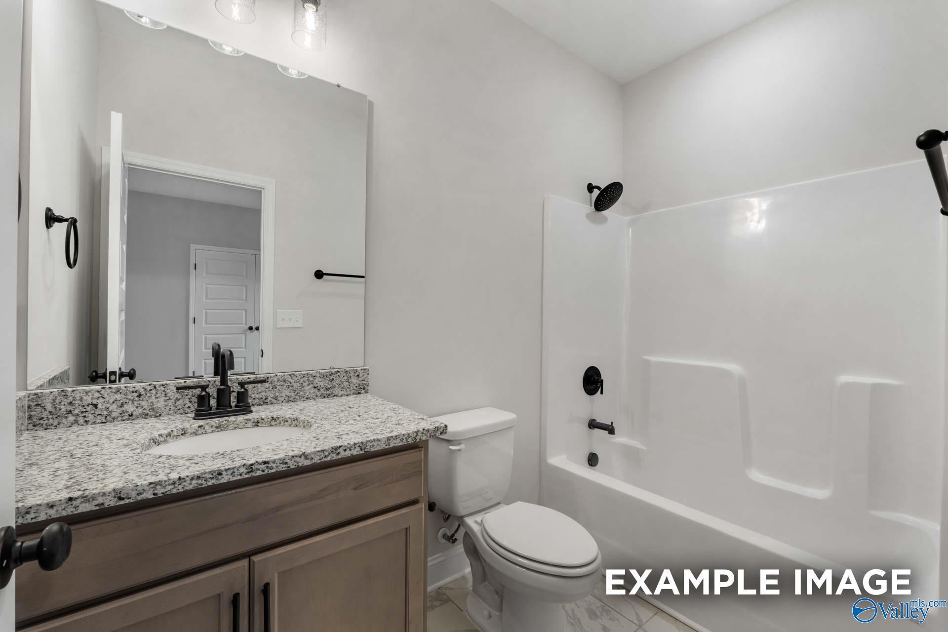 Modern master bathroom featuring granite vanity, single sink, toilet, and walk-in shower-tub in Davidson Homes The Finleigh, Meridianville, Alabama