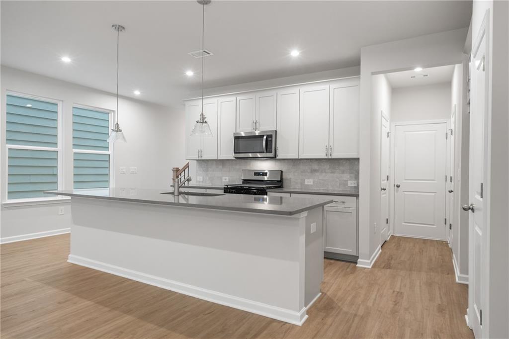 Bright modern kitchen with white shaker cabinets, stainless appliances, quartz island in Davidson Homes The Cary A, Kennesaw GA